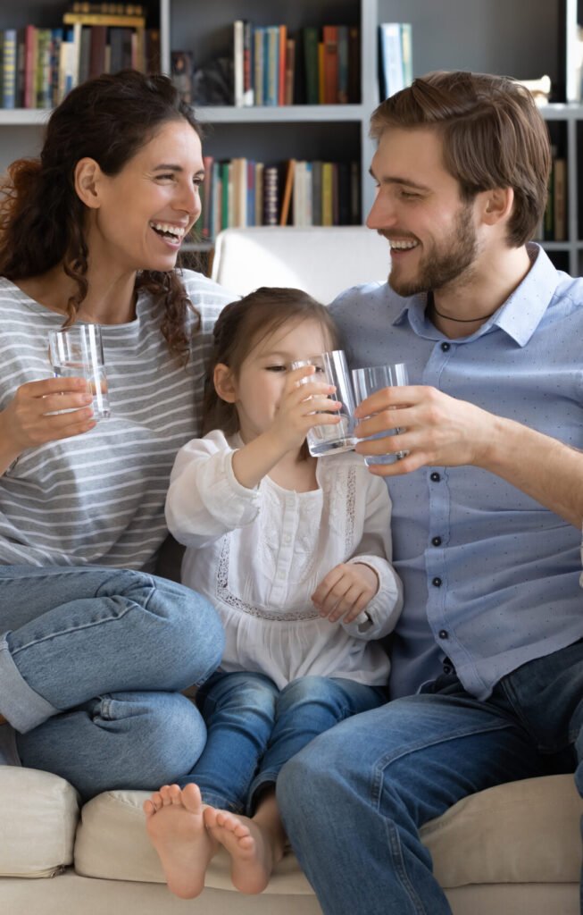 Rodina s dítětem pije čistou vodu z vlastního zdroje